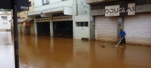 Cidadão tenta limpar detritos na tarde de terça-feira, após enchente