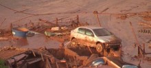 Carros foram carregados para cima das casas em Bento Rodrigues, e uma escola ficou completamente debaixo da lama - Foto de TV Globo